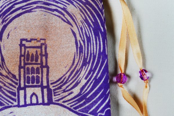 Glastonbury Tor Pouch, Mystical Avalon Tower on Hill with Glastonbury Spiral White Spring - Unbleached Cotton Pouch with Copper Spray and Purple Printing Close Up - Hand Printed with Hand Carved Lino Stamp